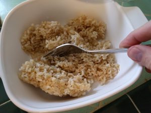 Using a fork to break up the block of frozen rice